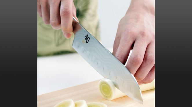 
                    Scalloped Santoku in use while cutting field garlic